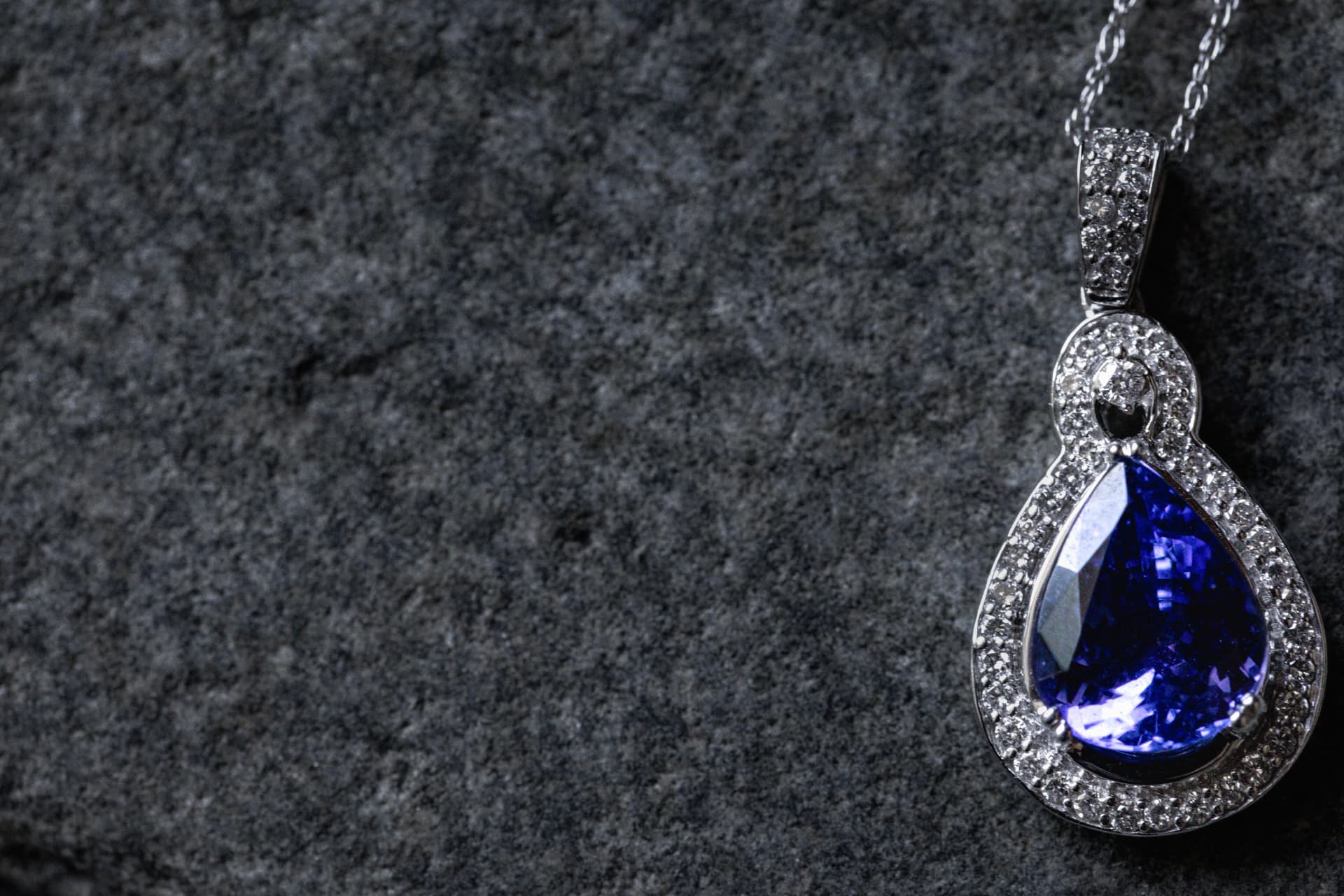 Pear-cut gemstone pendant framed with diamonds