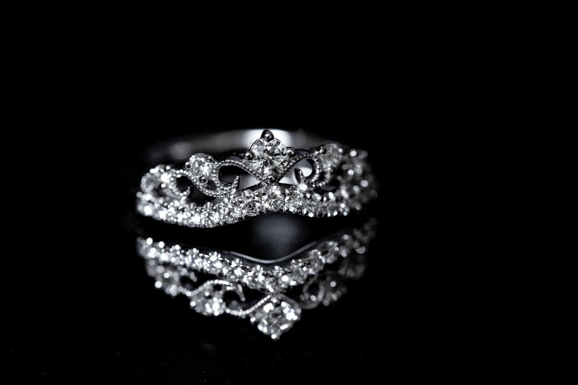 Crown-style diamond ring on a reflective surface