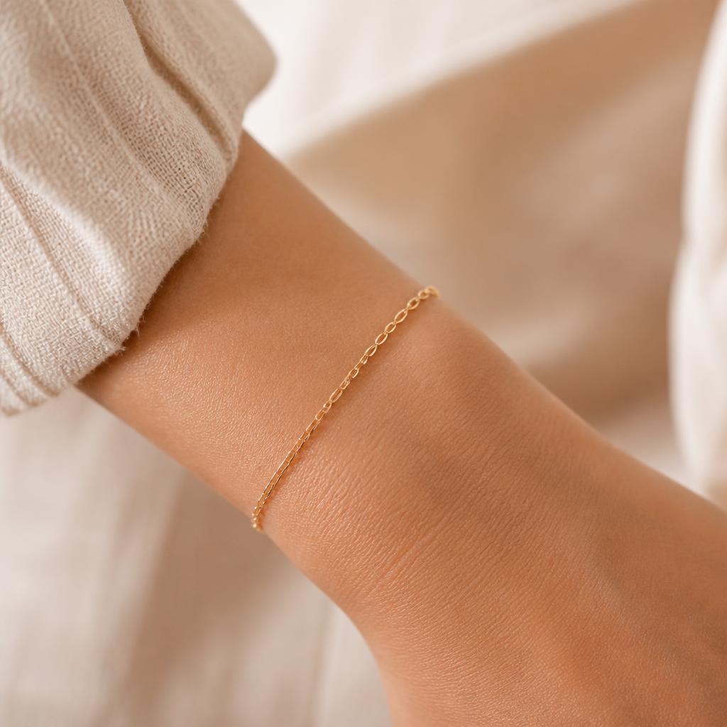 Delicate permanent gold chain bracelet on a wrist